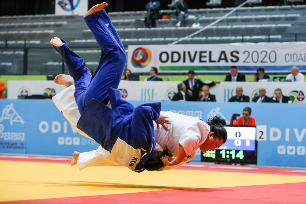 Hongyu Wang and an opponent are pictured as if they are hovering in the air during a throw