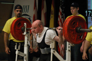 Powerlifter Stephen Brown of Great Britain strains his face as he lifts a heavy weight during a competition